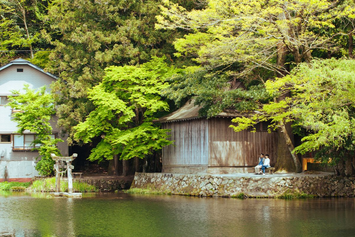 A quiet wooden building on the shore of Kinrinko Lake in Yufuin, surrounded by maple trees